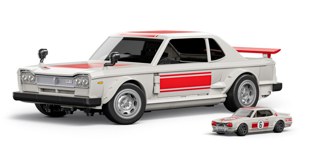 A large scale model of a race car in white with red accents, featuring details like dual side mirrors and a rear spoiler, next to a smaller version of the same car.
